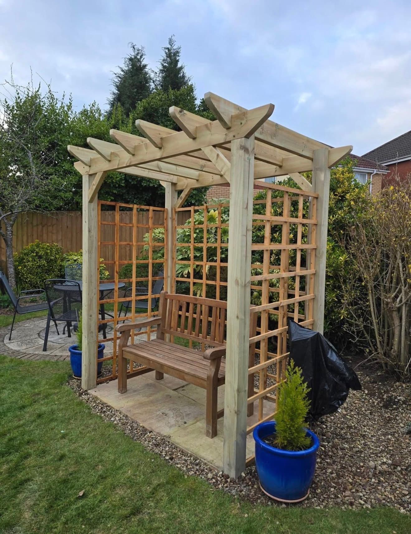 Timber pergola with trellis panels and bench seating in Cardiff