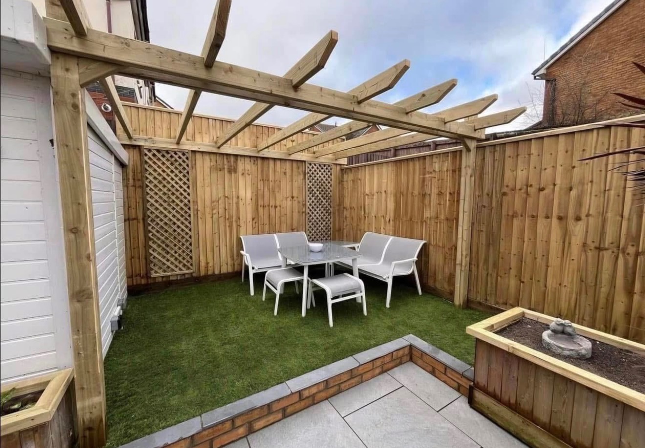 Pergola over a corner patio with artificial lawn in South Wales